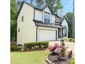 Two-story home featuring an attached garage and a well-maintained lawn with decorative plants at 210 Paris Dr, Lawrenceville, GA 30043