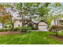 Rear exterior view of home featuring an attached garage, large windows, and well-maintained backyard at 4716 N Springs Ct, Atlanta, GA 30338