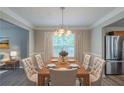 Formal dining room featuring an elegant chandelier, large windows, and seating for eight at 589 Arbor Ridge Dr, Stone Mountain, GA 30087