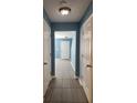 Hallway with neutral tile flooring and doors on either side at 5574 Fair Creek Way, Lithonia, GA 30038