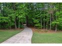 A long, winding driveway leads through a lush green forest at 5755 Hendrix Rd, Cumming, GA 30040