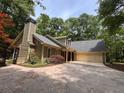 Charming home boasting a well-maintained roof, attached garage, and beautiful surrounding trees at 5755 Hendrix Rd, Cumming, GA 30040