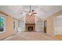 Cozy living room with a brick fireplace, built-in bookshelves, and a ceiling fan at 5755 Hendrix Rd, Cumming, GA 30040