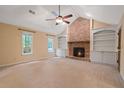 Cozy living room with a brick fireplace, built-in bookshelves, and a ceiling fan at 5755 Hendrix Rd, Cumming, GA 30040