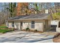 Side view of the home featuring a stucco exterior, windows, and access to a concrete patio area at 3510 Riviera Dr, Cumming, GA 30041