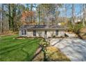 Charming single-story home with a well-maintained lawn and a cozy facade nestled among mature trees at 3510 Riviera Dr, Cumming, GA 30041