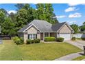 Well-maintained single-story brick home featuring a two-car garage and a green, manicured lawn at 4368 Magnolia Bay Ln, Snellville, GA 30039