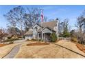 View of gray home with walkway, lawn, American flag, and manicured shrubs at 2109 Rugby Ave, Atlanta, GA 30337