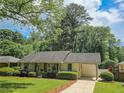 Charming single-story home with well-manicured lawn, mature shrubs, and covered parking at 2413 Hunting Valley Dr, Decatur, GA 30033