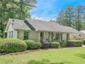 Charming single-story home with well-manicured lawn, mature shrubs, and covered parking at 2413 Hunting Valley Dr, Decatur, GA 30033