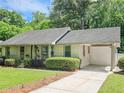 Charming single-story home with well-manicured lawn, mature shrubs, and covered parking at 2413 Hunting Valley Dr, Decatur, GA 30033