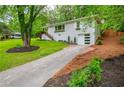 Exterior view of a grey painted brick home showcasing a long driveway and well maintained lawn at 2681 Linnwood Se Dr, Smyrna, GA 30080