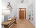 Bright foyer with light hardwood floors, console table, a wooden front door and stylish light fixture at 9770 Coleman Rd, Roswell, GA 30075