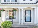 Close up on a charming front porch with a bench and hanging flower baskets at 338 Santa Anita Ave, Woodstock, GA 30189