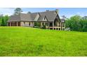 Lush green lawn around the rear of a two-story home featuring stone accents and a three-car garage at 1101 N Flat Rock Rd, Douglasville, GA 30134