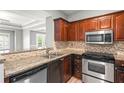 Modern kitchen featuring granite countertops, stainless steel appliances, and wood cabinets at 1502 River Green Nw Dr # 1502, Atlanta, GA 30327