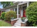 Inviting front porch of a brick home, adorned with potted plants and a bright red front door at 203 Lucerne St, Decatur, GA 30030