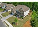 Aerial view of a brick house with manicured lawn, mature trees, and a paved driveway in a suburban setting at 319 Parkside Meadow Dr, Marietta, GA 30064