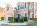 Close-up of a brick home showcasing a well-kept lawn, decorative bushes, and inviting front door at 335 Roberts Run Cv, Suwanee, GA 30024