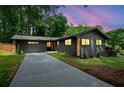 Beautiful home showcasing a long driveway leading to an updated exterior with professionally manicured landscaping at 3964 Gretna Green Dr, Decatur, GA 30035