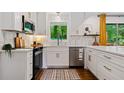 Bright kitchen featuring white cabinets, stainless steel appliances, and a view to a private backyard at 3964 Gretna Green Dr, Decatur, GA 30035