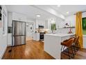 Modern kitchen featuring white cabinetry, stainless steel appliances, a waterfall island, and hardwood floors at 3964 Gretna Green Dr, Decatur, GA 30035