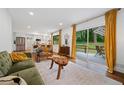 Open-concept living room with hardwood floors, bright windows, access to a patio, and seamlessly connected to the kitchen at 3964 Gretna Green Dr, Decatur, GA 30035