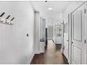 Hallway view to kitchen featuring hardwood floors, white walls, and stainless appliances at 44 Peachtree Ne Pl # 1929, Atlanta, GA 30309