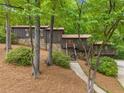 Home boasts a stone foundation, wood siding, and a multi-level deck overlooking the wooded surroundings at 475 Nottingham Dr, Marietta, GA 30066