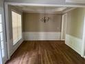 Dining room featuring hardwood floors, large windows, a modern chandelier, and paneled walls at 663 Prada Ct, Lawrenceville, GA 30043