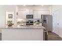 Modern kitchen with granite countertops, stainless steel appliances, and a view to the bedroom at 2010 Vidalia Ct, Dacula, GA 30019