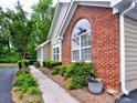 Side view of a home featuring brick and siding with manicured bushes and colorful flower pots at 106 Vintage Club Cir, Marietta, GA 30066