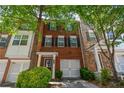A charming red brick townhome featuring black shutters and a convenient single-car garage at 2201 Landing Walk Dr, Duluth, GA 30097