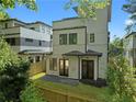 Back exterior view of this home with a modern fence and lush trees around at 88 Cleveland Unit B Se St, Atlanta, GA 30316