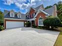 Brick home featuring a three-car garage and well-manicured landscaping at 1093 Spruce Creek Ln, Lawrenceville, GA 30045