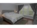 Bright bedroom with hardwood floors, large window, and neutral paint at 6614 Covered Bridge Way, Braselton, GA 30548