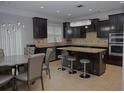 Modern kitchen featuring dark cabinets, granite countertops, and stainless steel appliances at 6614 Covered Bridge Way, Braselton, GA 30548