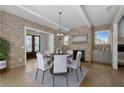 Elegant dining room with brick accent walls, a modern chandelier, and seating for six at 7235 Cordery Rd, Cumming, GA 30040