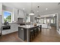Bright, open kitchen featuring a large island with seating, hardwood floors and stainless steel appliances at 7235 Cordery Rd, Cumming, GA 30040
