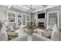 Comfortable living room with white sofas, a modern fireplace, exposed beams, and French doors at 7235 Cordery Rd, Cumming, GA 30040