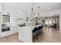Stylish white kitchen featuring an island with marble countertops, stainless steel appliances, and modern pendant lighting at 7275 Cordery Rd, Cumming, GA 30040