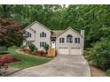 Charming home with manicured lawn, beautiful landscaping, and a two-car garage at 204 Queensbury Ct, Acworth, GA 30102