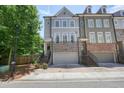 Attractive townhome with brick and gray facade, featuring a 2-car garage and inviting entrance at 2093 Callaway Nw Ct, Atlanta, GA 30318
