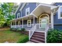 Close-up of the inviting front porch with stone accents and a light green front door at 219 Brick Mill Dr, Canton, GA 30115