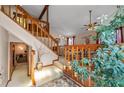 Inviting living room featuring a vaulted ceiling, wooden railing, and large plants at 140 N Star Sw Trl, Atlanta, GA 30331