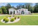 Expansive lawn and meticulous landscaping highlight this grand home's classic architecture at 2425 Wild Oak Ct, Stockbridge, GA 30281
