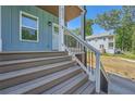 Home's entrance featuring a welcoming porch with metal railing and access steps at 632 Warren Ave, Scottdale, GA 30079