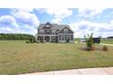 Inviting gray home with a charming front porch and well-manicured lawn at 125 Leveret Rd, Locust Grove, GA 30248
