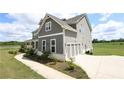 Side view of a two-story home with gray siding and a spacious three-car garage at 125 Leveret Rd, Locust Grove, GA 30248