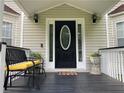 Inviting front porch features seating, plants, and a stylish front door at 2257 Rocksram Ct, Buford, GA 30519